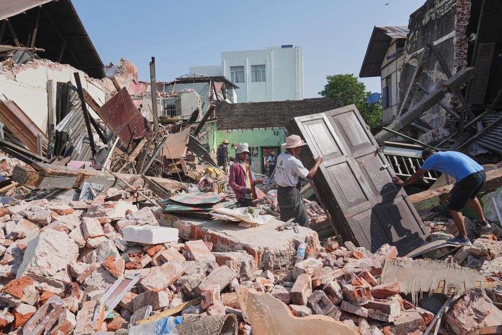 緬甸地震災情慘重,圖為內比都居民周二返回倒塌住處,收拾可用物品後撤離。(美聯社)