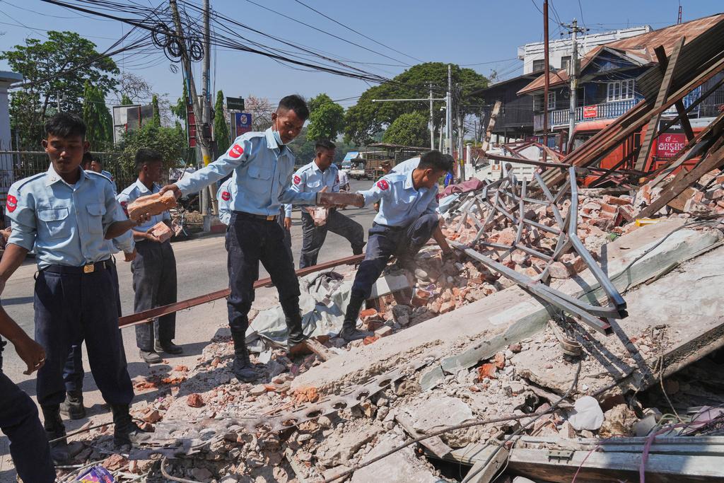 緬甸地震災情慘重,圖為緬甸軍人周二在內比都倒塌樓房徒手搬開瓦礫搜救。(美聯社)