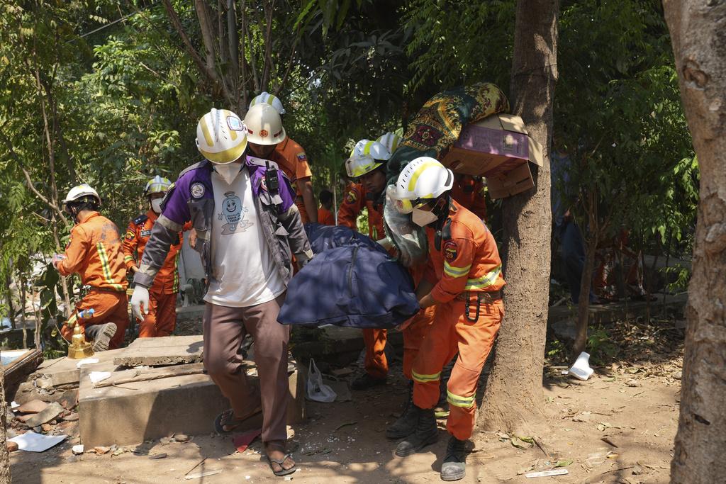 緬甸地震,圖為救援隊周二在內比都倒塌房屋搜索,抬出遺體。(美聯社)