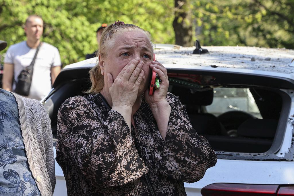 烏克蘭東南部城市札波羅熱一處住宅區周二遭俄軍攻擊,有居民目擊家園盡毀,顯得悲傷。(美聯社)