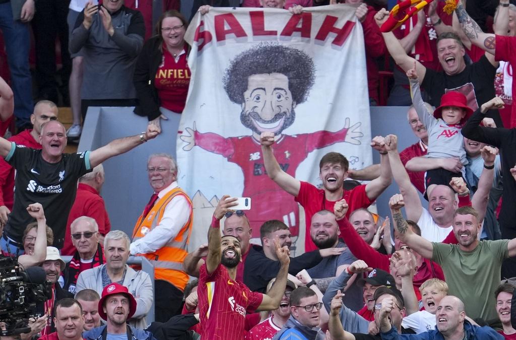 利物浦球迷高舉沙拿卡通。(美聯社)