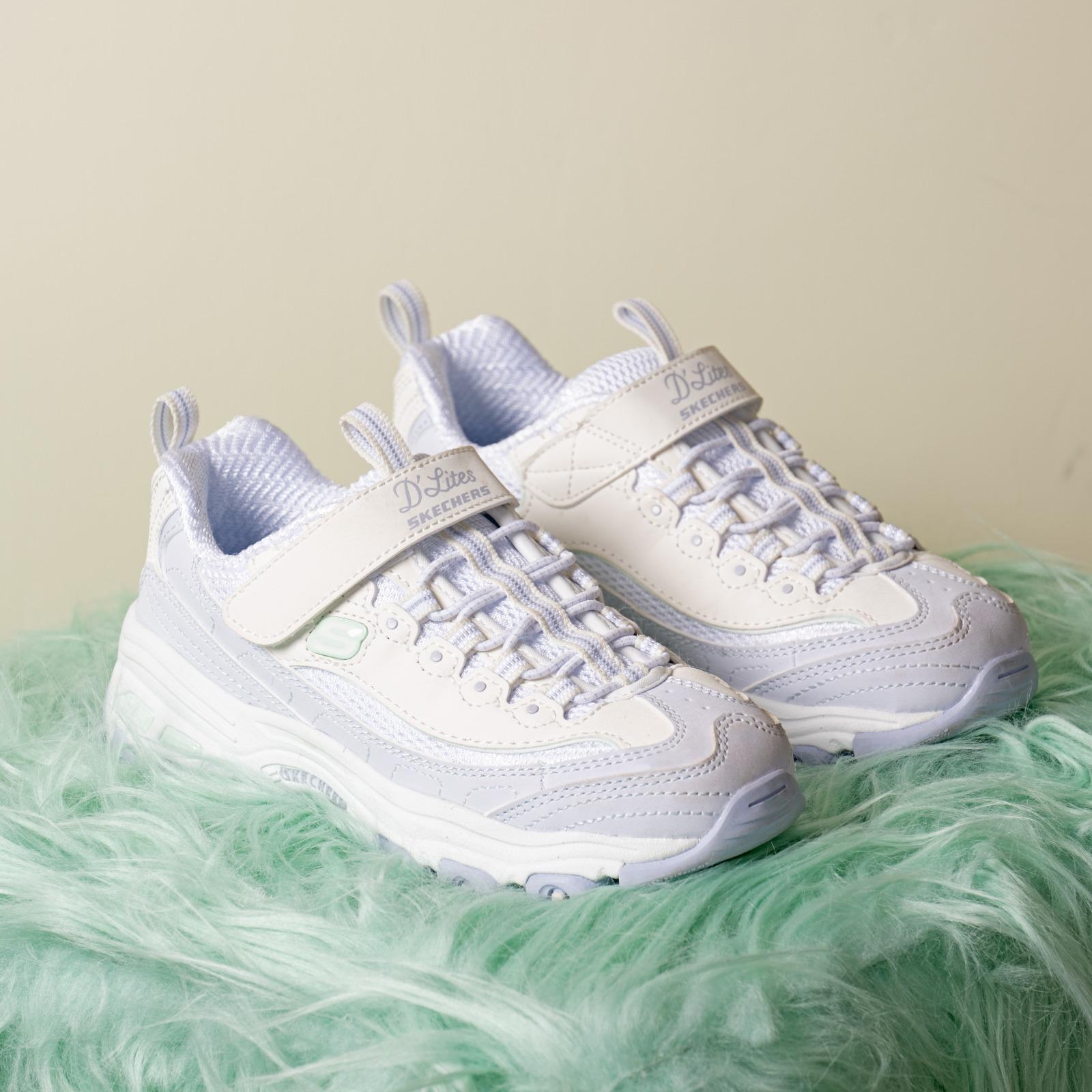 D'Lites首度搭載Hands Free Slip-ins®科技 熊貓主調鞋款同步登場 延續系列靈感,Panda Pack同步推出多款成人及小童D’Lites鞋款,演繹從頭到腳的熊貓系穿搭。是次全新女裝鞋Hands Free Slip-ins®: D'Lites,首度將品牌王牌舒適科技SKECHERS Hands Free Slip-ins®站立穿脫科技注入D’Lites經典輪廓,配合專利Heel Pillow™鞋跟設計,讓用家無需彎腰或動手即可輕鬆穿上鞋履,實現解放雙手、「一秒閃穿,即穿即走」的便捷穿脫體驗。另外,D’Lites亦配有Air-Cooled Memory Foam®透氣記憶棉鞋墊,帶來舒適且穩定的承托效能。鞋面採用多層皮革、網布及針織物料拼接,結合條紋鞋帶細節,設計感與機能兼備。加上1.5吋加高鞋跟,修飾身形比例,為穿搭增添時尚感。