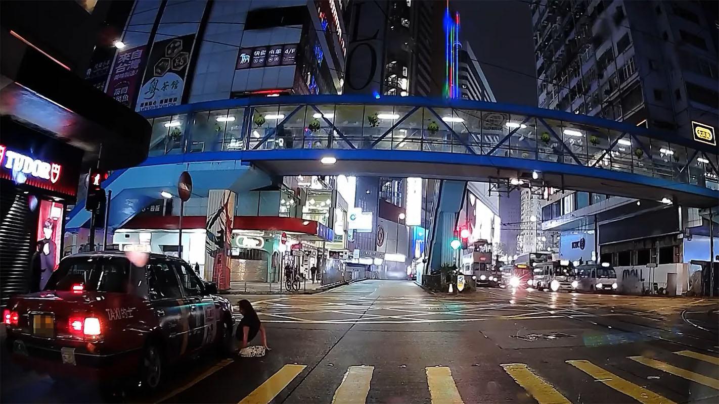 銅鑼灣有女子過馬路衝燈尾時不幸跣腳墮地,幸駛至的士及時煞車未有輾過雙腿。(網上影片截圖)