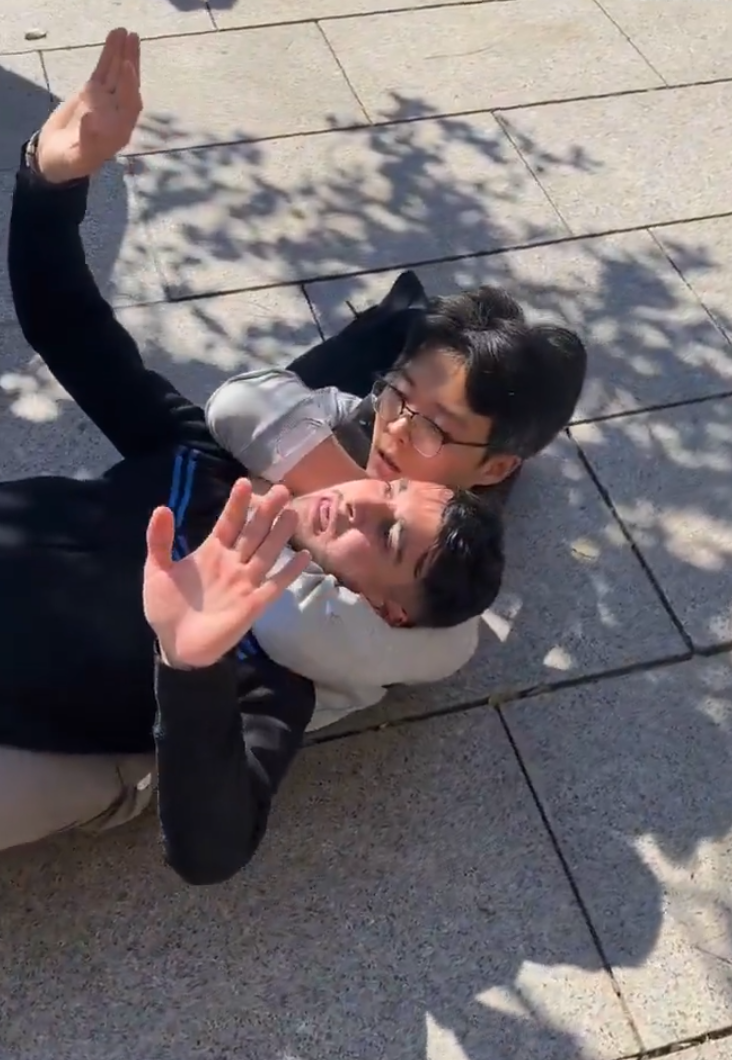 山東一名青年近日在西班牙巴塞隆拿街頭遇到小偷,當場使出鎖喉招式把對方制服,獲當地警員和市民讚賞。(影片截圖)