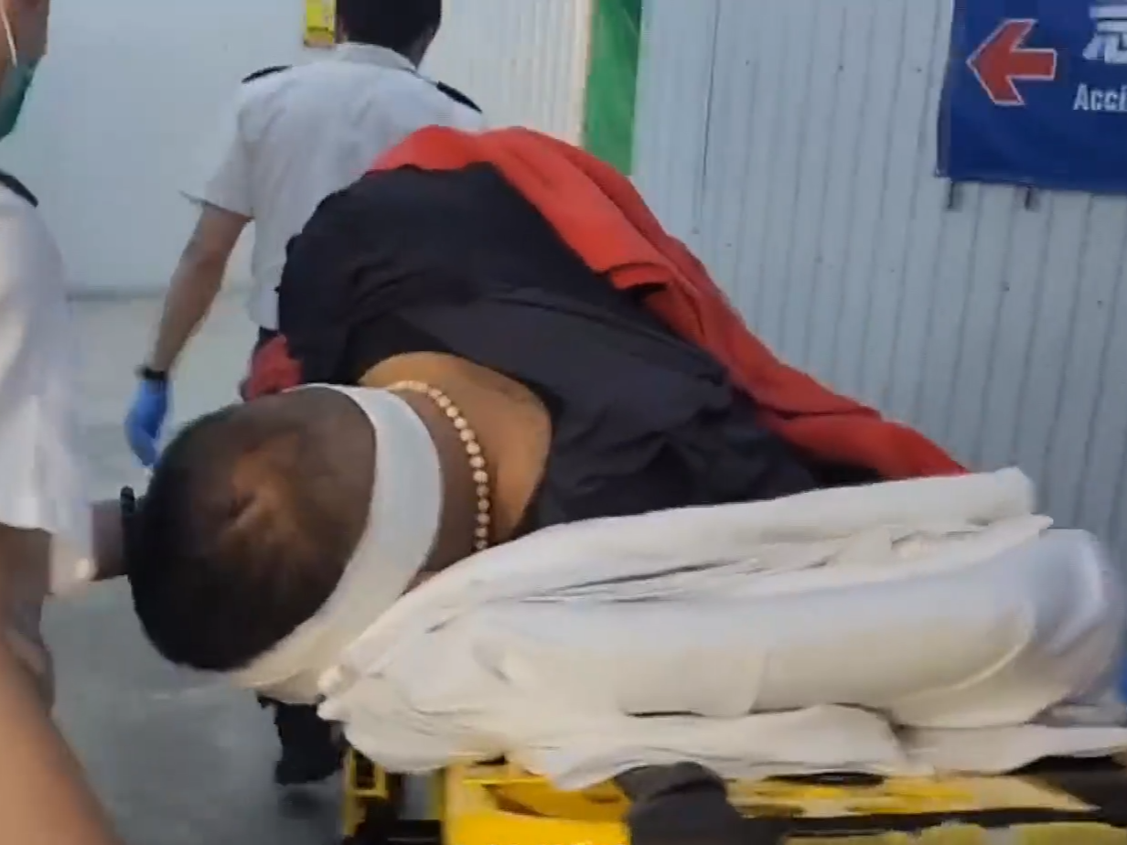 被捕男子頭部及手腳擦傷,鎖上手銬送往聯合醫院治理。(有線新聞截圖)