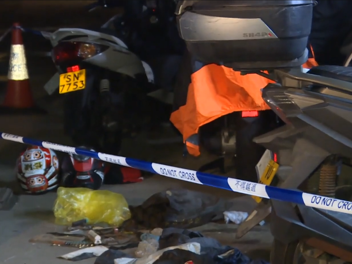現場地上遺下兩個頭盔及汽車零件。(有線新聞截圖)