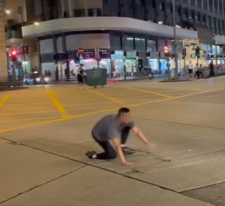 一名的士司機離開其座駕,在馬路上追趕一名騎單車的男子,期間的士司機撲前意圖捉住單車惟失手撲空,整個人如滾地葫蘆向前倒地。(Threads)