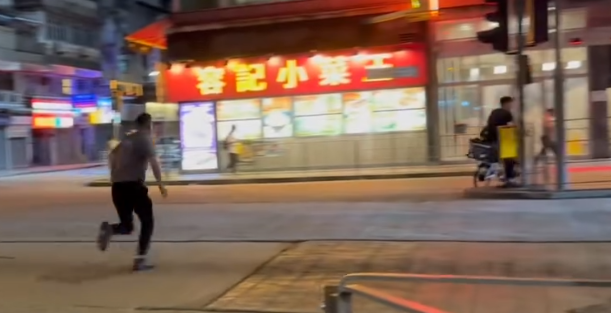 一名的士司機離開其座駕,在馬路上追趕一名騎單車的男子,期間的士司機撲前意圖捉住單車惟失手撲空,整個人如滾地葫蘆向前倒地。(Threads)