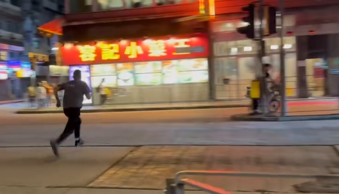 一名的士司機離開其座駕,在馬路上追趕一名騎單車的男子,期間的士司機撲前意圖捉住單車惟失手撲空,整個人如滾地葫蘆向前倒地。(Threads)