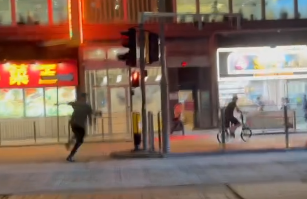 一名的士司機離開其座駕,在馬路上追趕一名騎單車的男子,期間的士司機撲前意圖捉住單車惟失手撲空,整個人如滾地葫蘆向前倒地。(Threads)