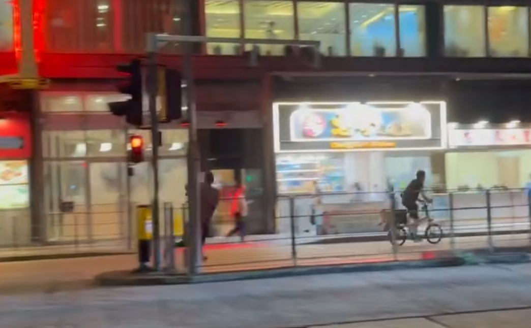 一名的士司機離開其座駕,在馬路上追趕一名騎單車的男子,期間的士司機撲前意圖捉住單車惟失手撲空,整個人如滾地葫蘆向前倒地。(Threads)