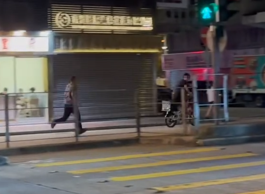 一名的士司機離開其座駕,在馬路上追趕一名騎單車的男子,期間的士司機撲前意圖捉住單車惟失手撲空,整個人如滾地葫蘆向前倒地。(Threads)