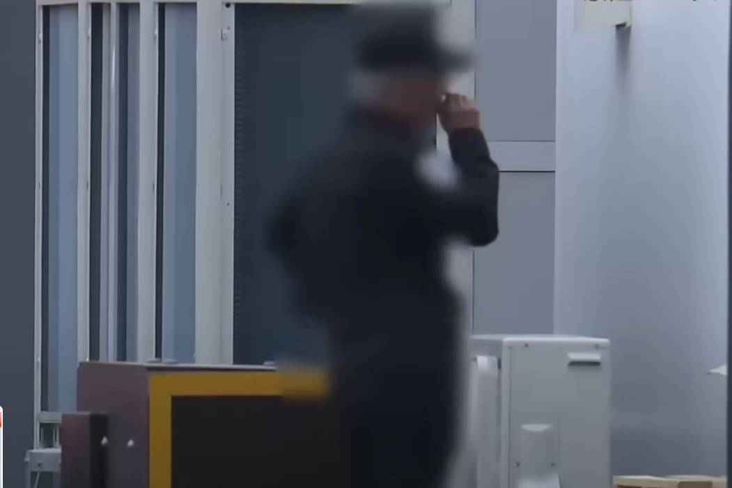 日本媒體拍到世博會工作人員違規吸煙。(新聞截圖)