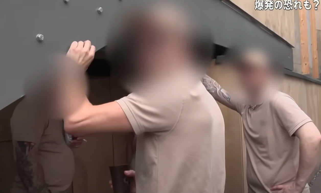 世博會內外國工作人員圍在一起吸煙。(新聞截圖)