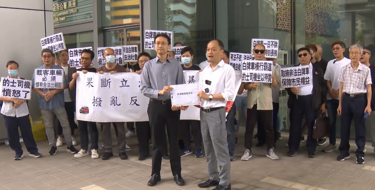 20多名的士業界人士今日到西九龍政府合署外請願,要求政府嚴厲打擊非法白牌車。(有線新聞畫面)
