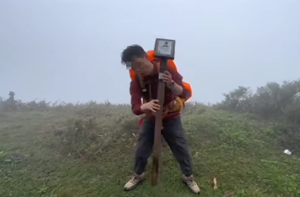 一名操普通話的男子在大帽山移走麥理浩徑一枝標距柱,並架在肩上奔跑,之後放回原位。(小紅書)