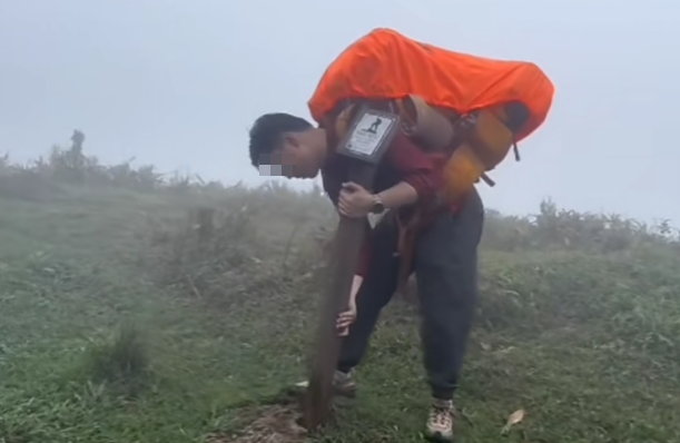 一名操普通話的男子在大帽山移走麥理浩徑一枝標距柱,並架在肩上奔跑,之後放回原位。(小紅書)