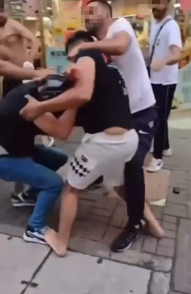 多名南亞裔男子在牛頭角街頭糾纏動武,其中有人被打到跌頭盔甩拖鞋,有人被打到跌在地上。 (FB車cam L(香港群組))