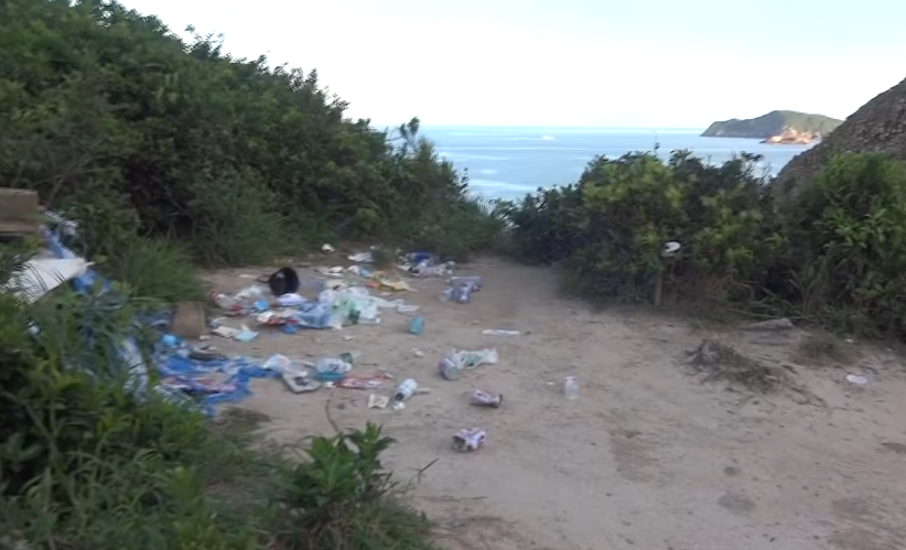 西貢萬宜水庫東壩近日成為遊客旅遊熱點,有網民近日於東壩近破邊洲一處泥地發現大堆垃圾,大部分食物包裝均印有簡體字,立即拍片公審,擔憂污染水源及郊野環境。(fb影片截圖)