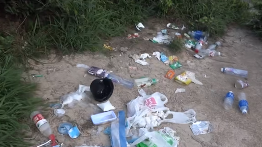 西貢萬宜水庫東壩近日成為遊客旅遊熱點,有網民近日於東壩近破邊洲一處泥地發現大堆垃圾,大部分食物包裝均印有簡體字,立即拍片公審,擔憂污染水源及郊野環境。(fb影片截圖)