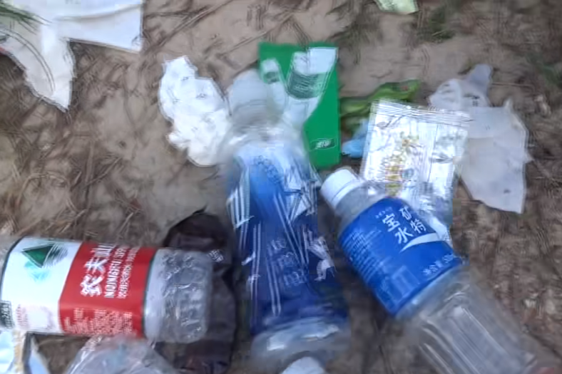 西貢萬宜水庫東壩近日成為遊客旅遊熱點,有網民近日於東壩近破邊洲一處泥地發現大堆垃圾,大部分食物包裝均印有簡體字,立即拍片公審,擔憂污染水源及郊野環境。(fb影片截圖)