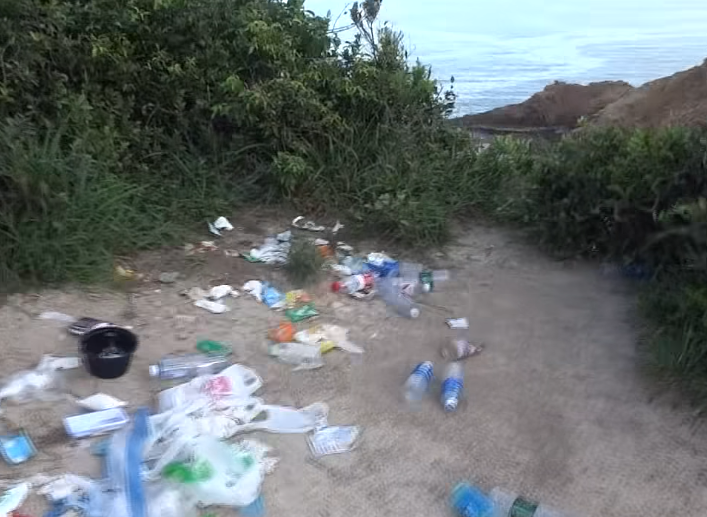 西貢萬宜水庫東壩近日成為遊客旅遊熱點,有網民近日於東壩近破邊洲一處泥地發現大堆垃圾,大部分食物包裝均印有簡體字,立即拍片公審,擔憂污染水源及郊野環境。(fb影片截圖)