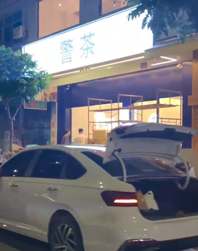 廣東廣州增城區荔城街一間即將開業的茶飲店因將店名取名為「警茶」,玻璃櫥窗上還張貼著身穿類似警察服裝的卡通人物圖案,左手拿着一杯飲品。(影片截圖)