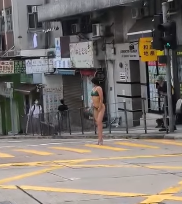 有網民上載影片,現場在西營盤西邊街及皇后大道西交界,一名身穿三點式泳衣高跟鞋的長髮女子,在班馬綫展示其「健美」身段,當時行人過路交通燈為綠色人像,女子期間挺胸收腹、撥頭髮轉身翹股,讓前方及行人路的兩名攝影師拍攝,可見她似乎有一定拍攝經驗,途經市民紛紛注視,更有年輕男子加入「打卡」行列。(IG影片)