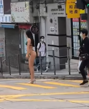有網民上載影片,現場在西營盤西邊街及皇后大道西交界,一名身穿三點式泳衣高跟鞋的長髮女子,在班馬綫展示其「健美」身段,當時行人過路交通燈為綠色人像,女子期間挺胸收腹、撥頭髮轉身翹股,讓前方及行人路的兩名攝影師拍攝,可見她似乎有一定拍攝經驗,途經市民紛紛注視,更有年輕男子加入「打卡」行列。(IG影片)