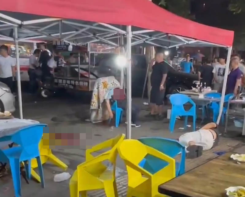 湖北武漢周日(18日)晚上一間燒烤店發生槍擊事件,影片可見有一人疑似被「行刑式」頭部中彈,躺在椅子上失去知覺,另有兩人受傷躺地,滿地血漬。(影片截圖)