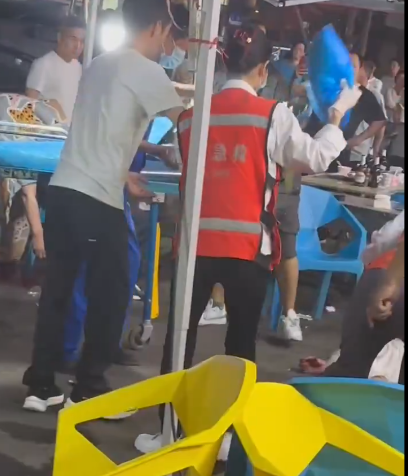 湖北武漢周日(18日)晚上一間燒烤店發生槍擊事件,影片可見有一人疑似被「行刑式」頭部中彈,躺在椅子上失去知覺,另有兩人受傷躺地,滿地血漬。(影片截圖)