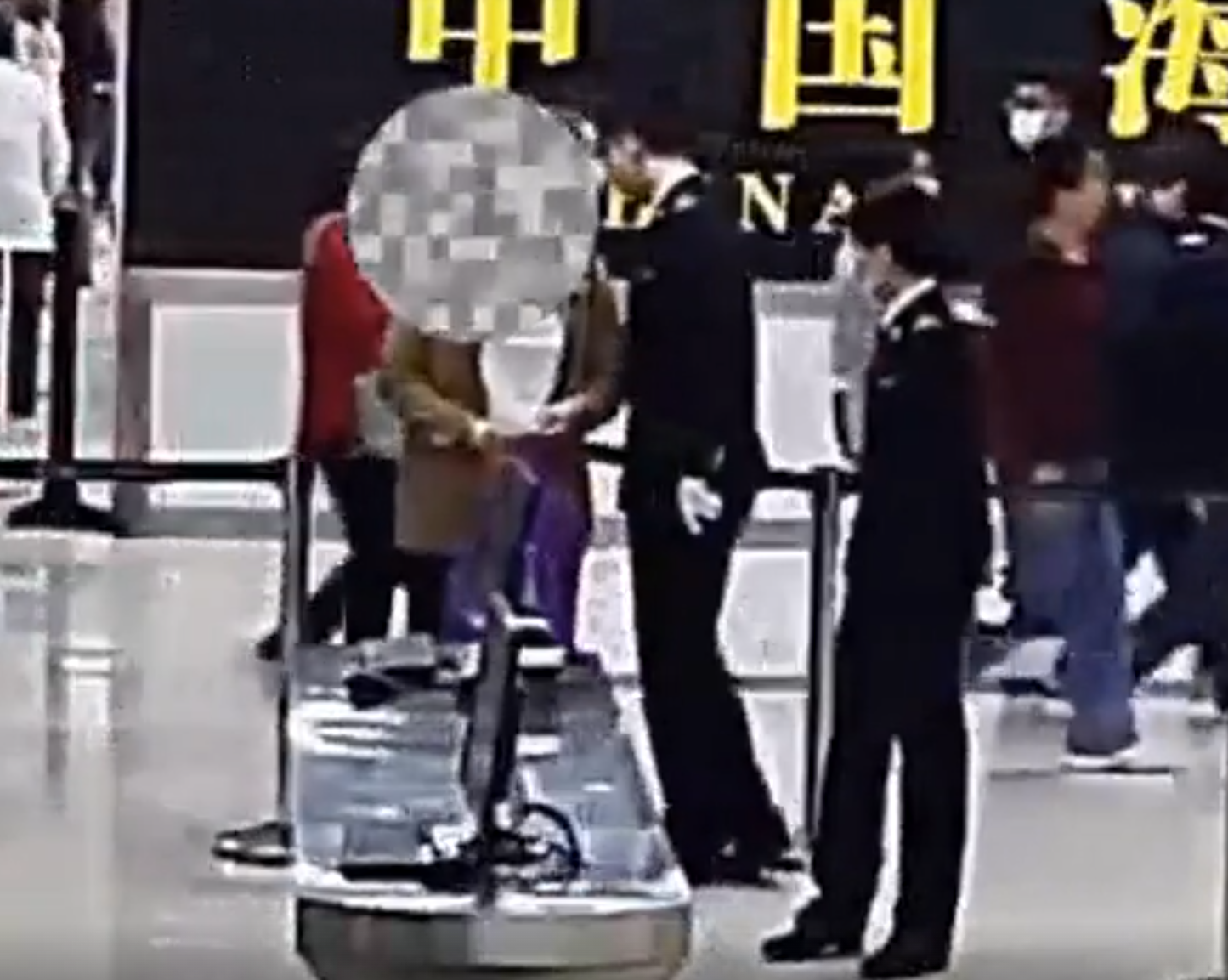 內地海關公布影片所見,當時一名身穿啡色外套的涉案女子過關被關員截停,關員在一條衞生巾中間取出分裝成小包的鑽石。(內地海關)