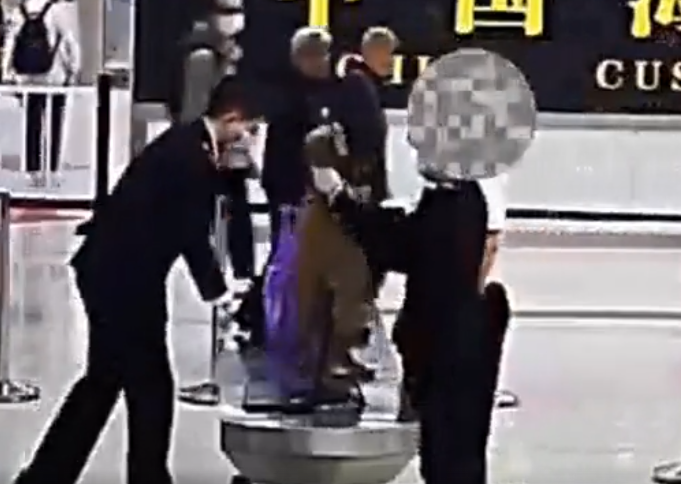 內地海關公布影片所見,當時一名身穿啡色外套的涉案女子過關被關員截停,關員在一條衞生巾中間取出分裝成小包的鑽石。(內地海關)