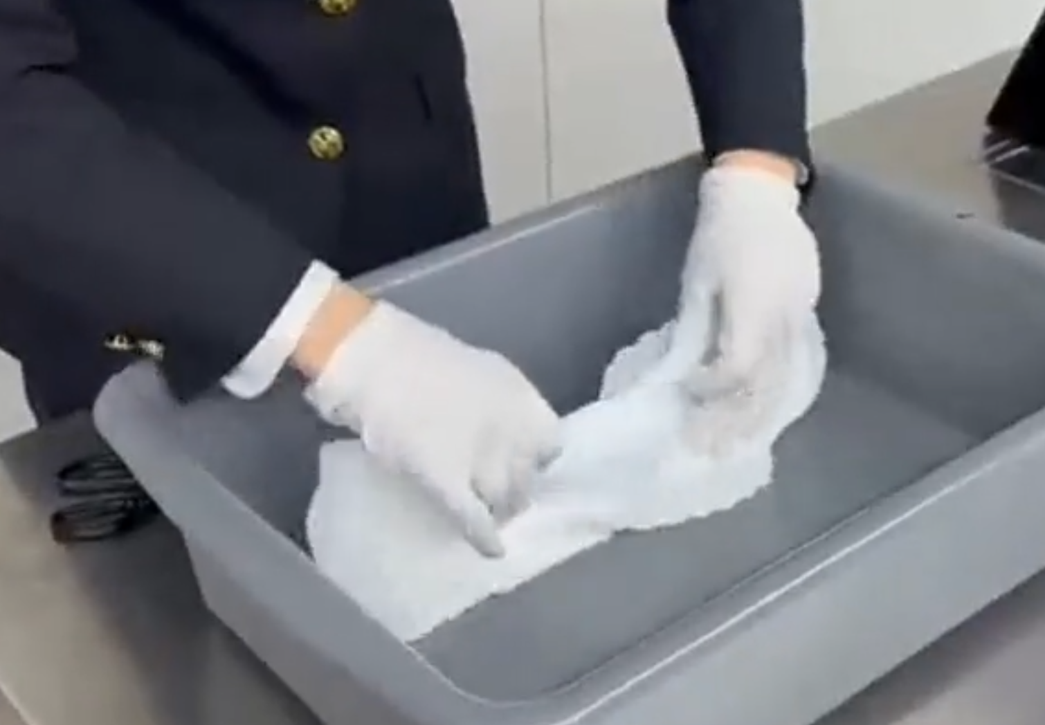 內地海關公布影片所見,當時一名身穿啡色外套的涉案女子過關被關員截停,關員在一條衞生巾中間取出分裝成小包的鑽石。(內地海關)