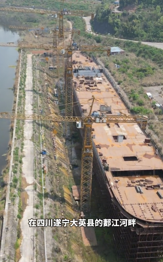 四川復刻版「鐵達尼號」2014年5月開建至今仍未完工。有網民近日發布航拍影片,指這座藏身於四川大英縣江邊船塢內的巨輪只具雛形鏽跡斑斑。(影片截圖)