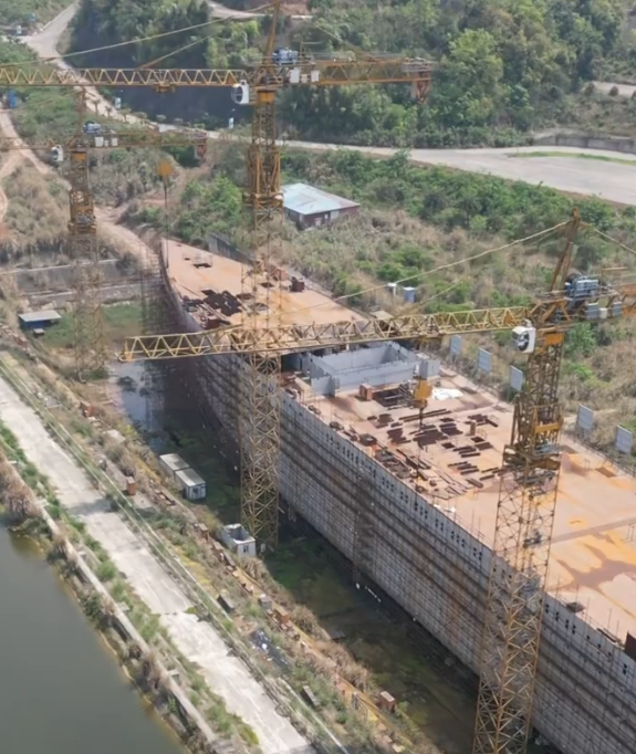 四川復刻版「鐵達尼號」2014年5月開建至今仍未完工。有網民近日發布航拍影片,指這座藏身於四川大英縣江邊船塢內的巨輪只具雛形鏽跡斑斑。(影片截圖)