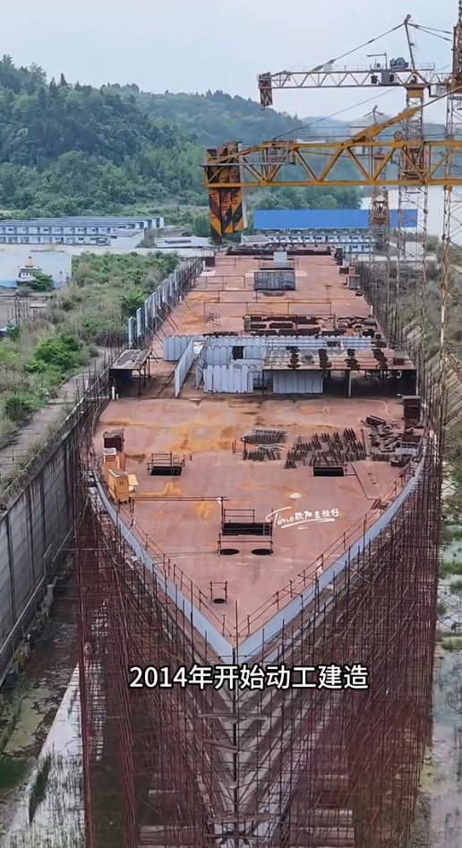 四川復刻版「鐵達尼號」2014年5月開建至今仍未完工。有網民近日發布航拍影片,指這座藏身於四川大英縣江邊船塢內的巨輪只具雛形鏽跡斑斑。(影片截圖)