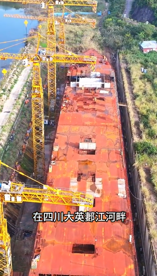 四川復刻版「鐵達尼號」2014年5月開建至今仍未完工。有網民近日發布航拍影片,指這座藏身於四川大英縣江邊船塢內的巨輪只具雛形鏽跡斑斑。(影片截圖)