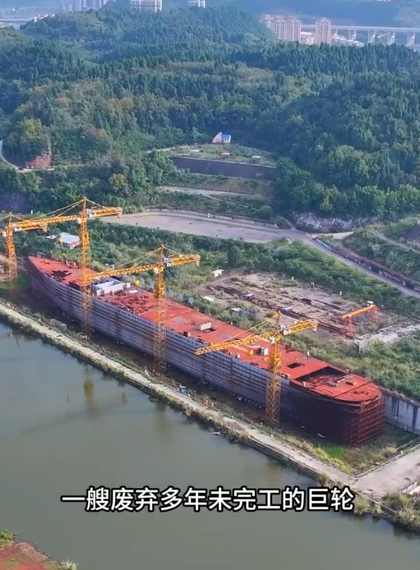 四川復刻版「鐵達尼號」2014年5月開建至今仍未完工。有網民近日發布航拍影片,指這座藏身於四川大英縣江邊船塢內的巨輪只具雛形鏽跡斑斑。(影片截圖)