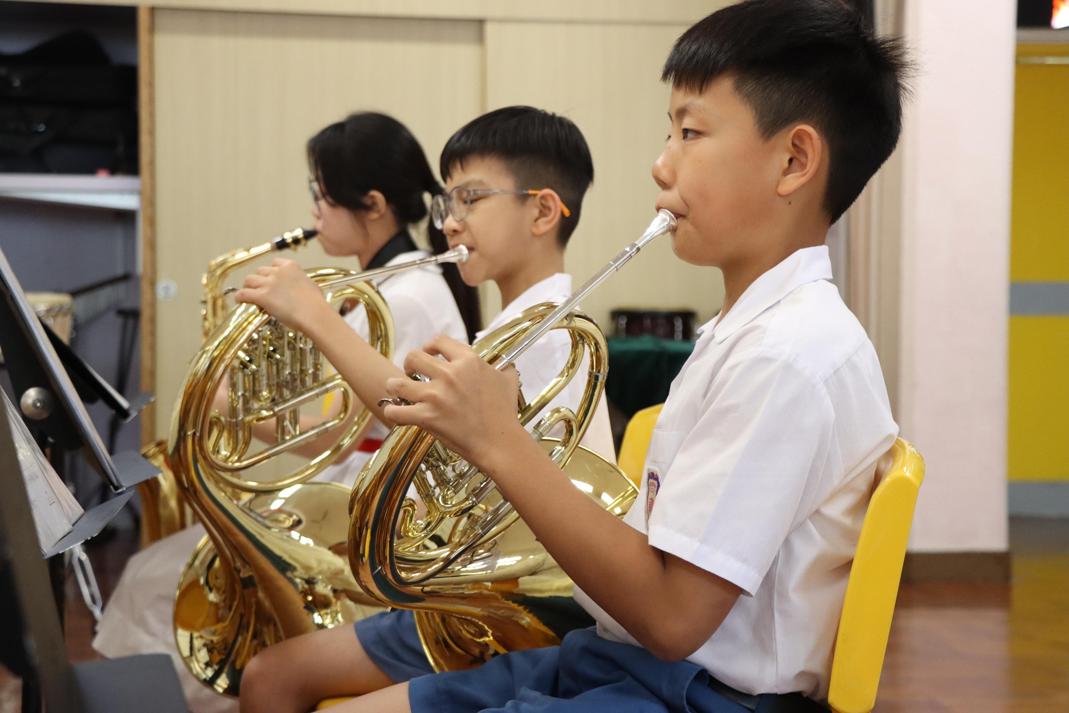 陳舜寧(右)獲老師推薦加入管樂團。(學校提供照片)