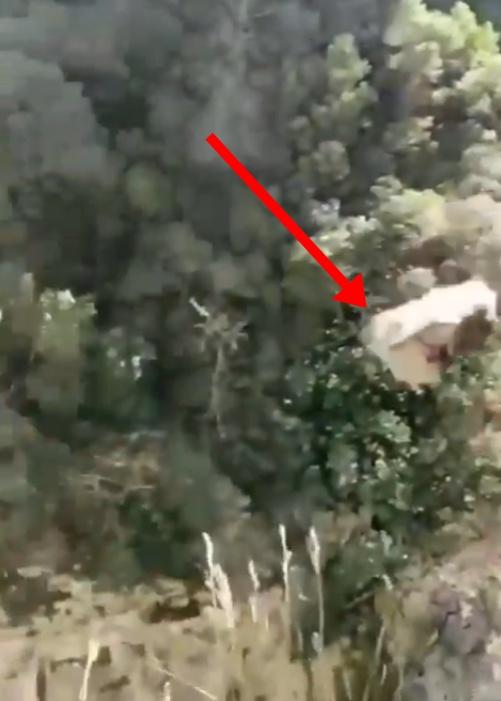 男遊客把大石頭從高處將往懸崖扔下。(X)