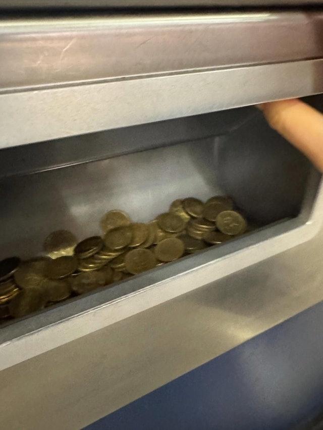相片顯示售票機的找續盤有一大堆5毫子,亦見樓主雙手捧著一堆5毫子。(Threads)