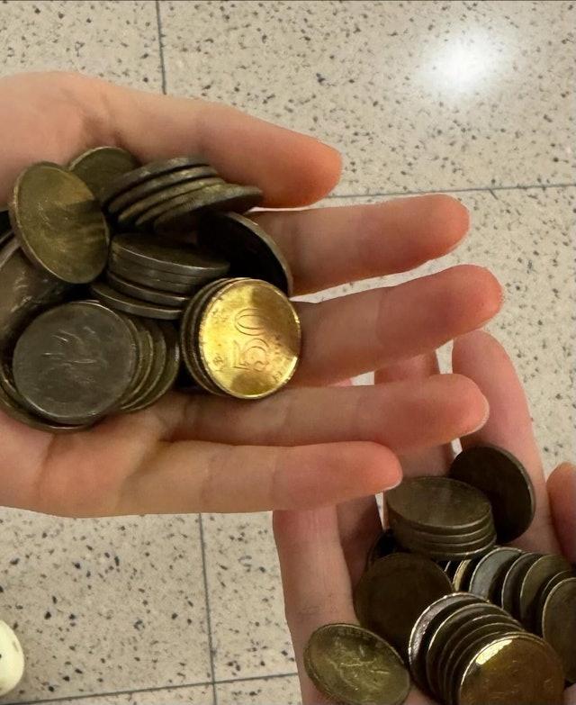 相片顯示售票機的找續盤有一大堆5毫子,亦見樓主雙手捧著一堆5毫子。(Threads)