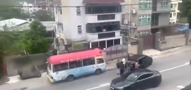 紅色小巴被黑色私家車閘停。(網上片段截圖)