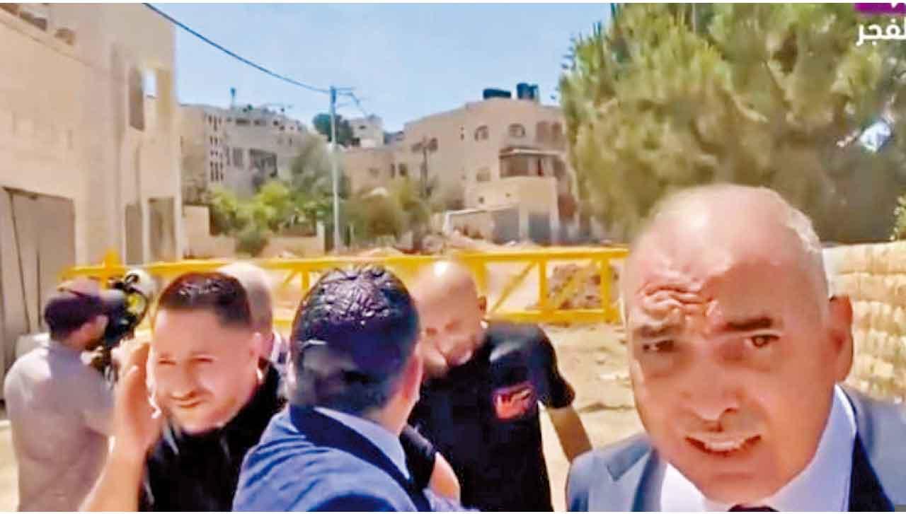 代表團成員和記者站在黃色路障前,突傳出槍響。(互聯網)