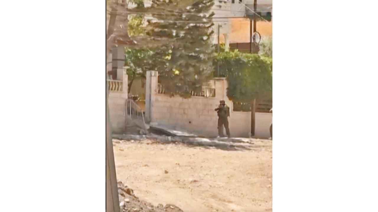 以軍在遠處舉槍。