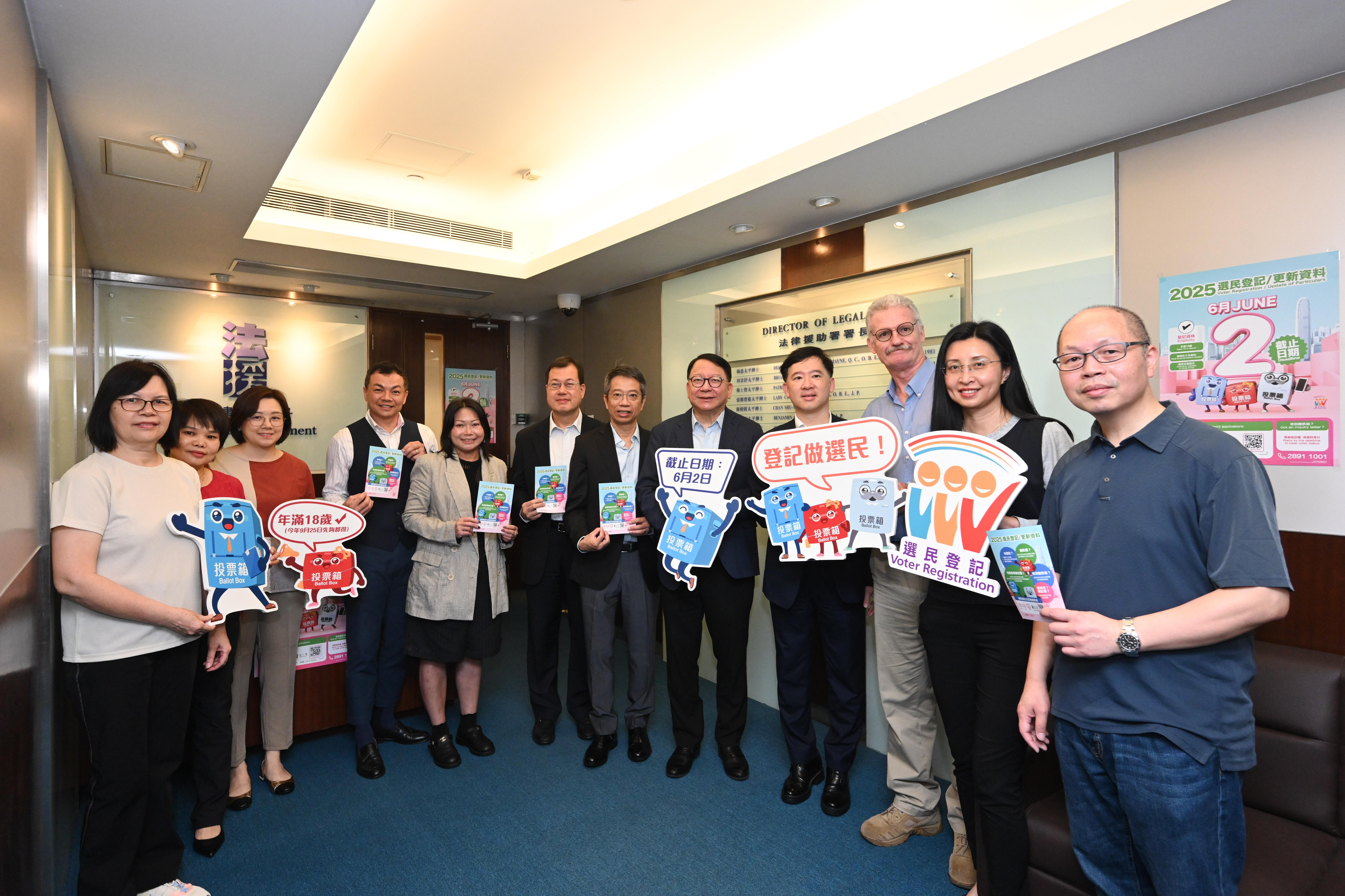 圖示陳國基(右五)、署理政制及內地事務局局長胡健民(右四)、公務員事務局常任秘書長梁卓文(右六)、法律援助署署長莊因東(左六)和中央評議會代表在法律援助署合照。(政府新聞處)