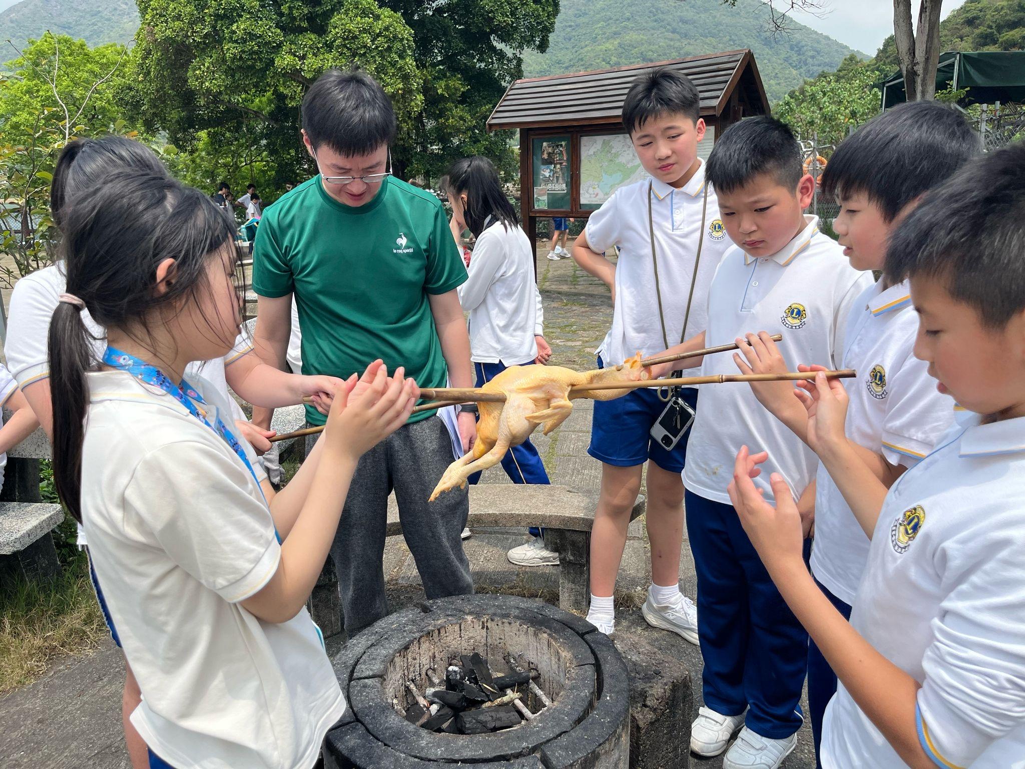 學生自己一手一腳完成穿雞、燒雞,以至斬雞等步驟。(學校提供照片)