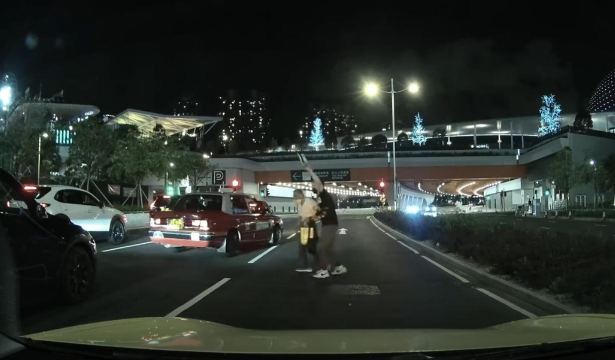 啟德體育園外老翁疑跌傷爬出馬路,好心司機「護駕」扶過路。(YouTube影片截圖)