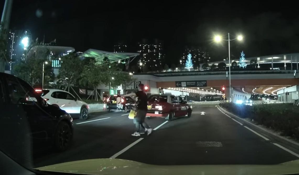 啟德體育園外老翁疑跌傷爬出馬路,好心司機「護駕」扶過路。(YouTube影片截圖)